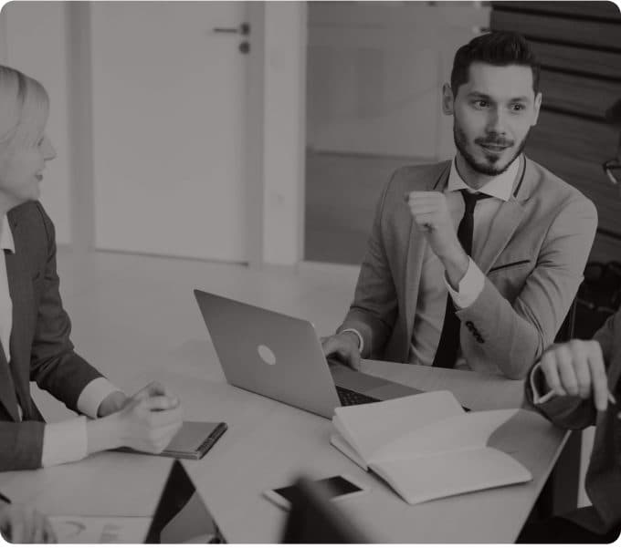 An agent listening in a meeting with colleagues around a laptop