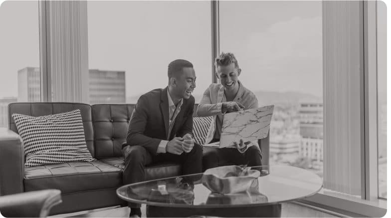 Two people talking across a coffee table in a city apartment