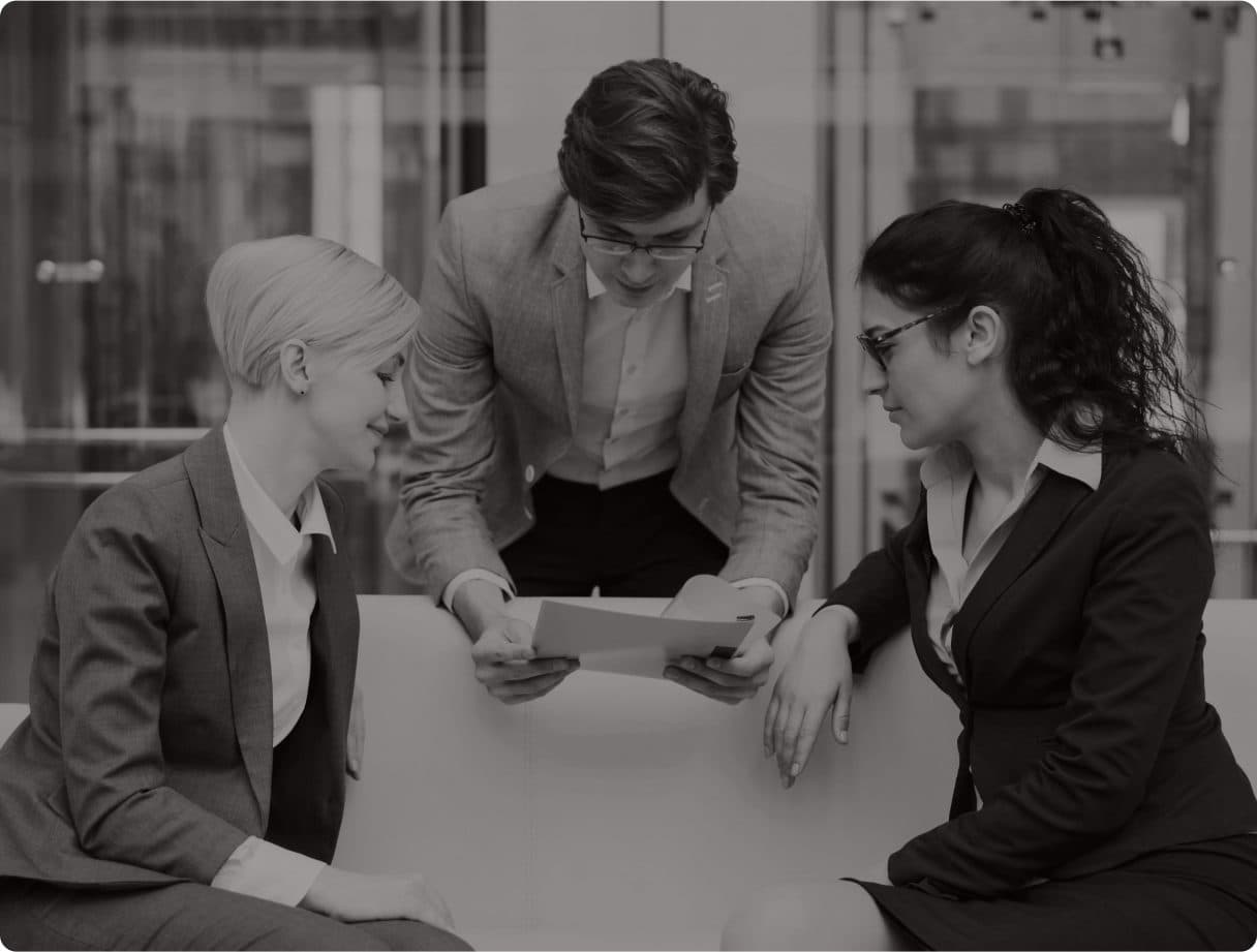Three colleagues reviewing a document together across a table